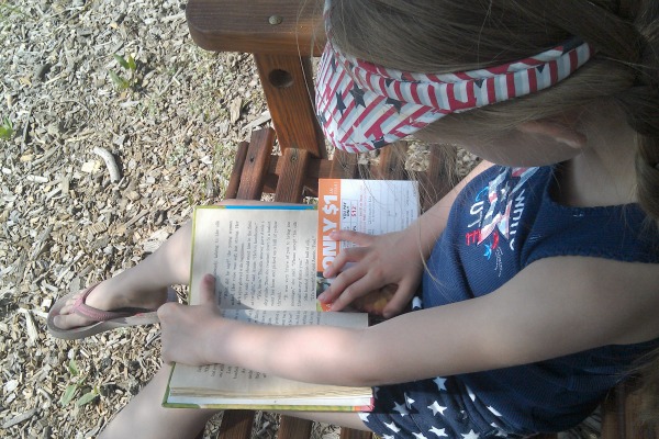 Madeline reading on the cabin swing